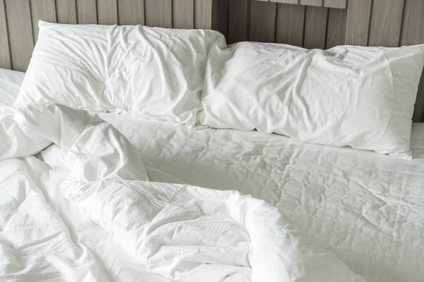 Cama arrugada con decoración de almohada blanca desordenada en el dormitorio — Foto de Stock