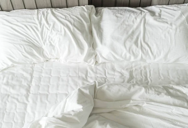 Cama arrugada con decoración de almohada blanca desordenada en el dormitorio — Foto de Stock