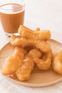 derin yağda kızartılmış hamur sopa ile süt çay