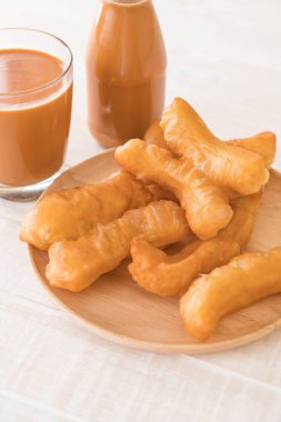 derin yağda kızartılmış hamur sopa ile süt çay