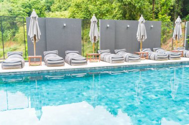 Güzel lüks şemsiye ve sandalye etrafında Açık Yüzme Havuzu