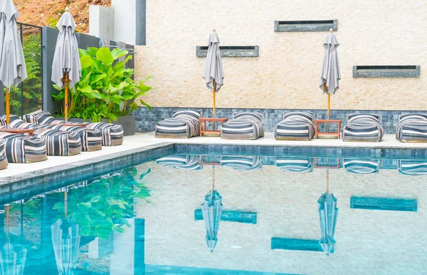 Belo guarda-chuva de luxo e cadeira em torno da piscina exterior — Fotografia de Stock