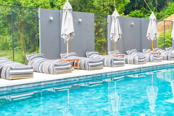 Piękny, luksusowy parasol i krzesła wokół odkrytego basenu — Zdjęcie stockowe