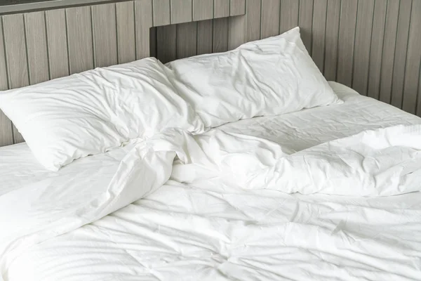 Cama arrugada con decoración de almohada blanca desordenada en el dormitorio — Foto de Stock