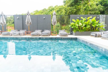 Güzel lüks şemsiye ve sandalye etrafında Açık Yüzme Havuzu