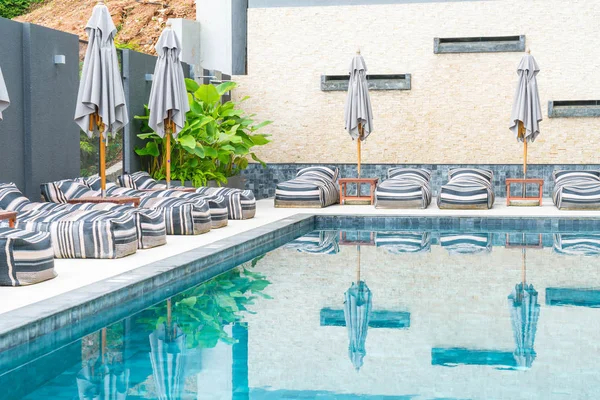 Belo guarda-chuva de luxo e cadeira em torno da piscina exterior — Fotografia de Stock