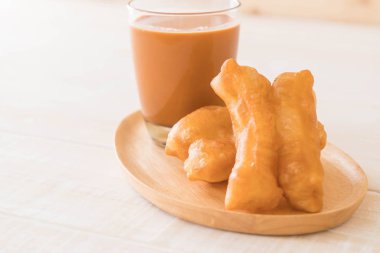 derin yağda kızartılmış hamur sopa ile süt çay