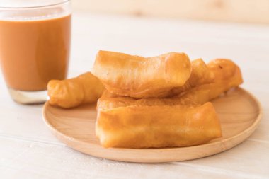 derin yağda kızartılmış hamur sopa ile süt çay