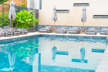 Güzel lüks şemsiye ve sandalye etrafında Açık Yüzme Havuzu