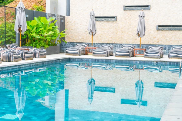 Belo guarda-chuva de luxo e cadeira em torno da piscina exterior — Fotografia de Stock