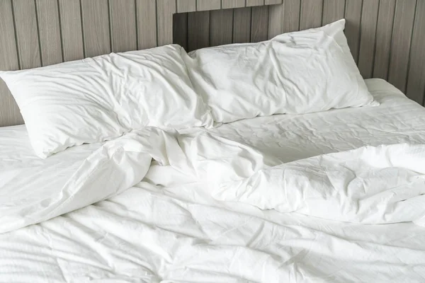 Cama arrugada con decoración de almohada blanca desordenada en el dormitorio — Foto de Stock