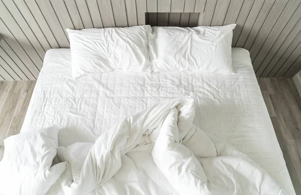 Cama arrugada con decoración de almohada blanca desordenada en el dormitorio — Foto de Stock