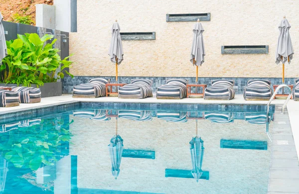 美しい高級傘と屋外スイミング プールの周りの椅子 — ストック写真