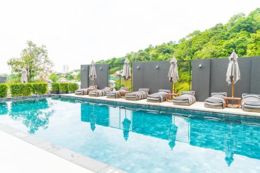 Güzel lüks şemsiye ve sandalye etrafında Açık Yüzme Havuzu