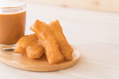 derin yağda kızartılmış hamur sopa ile süt çay