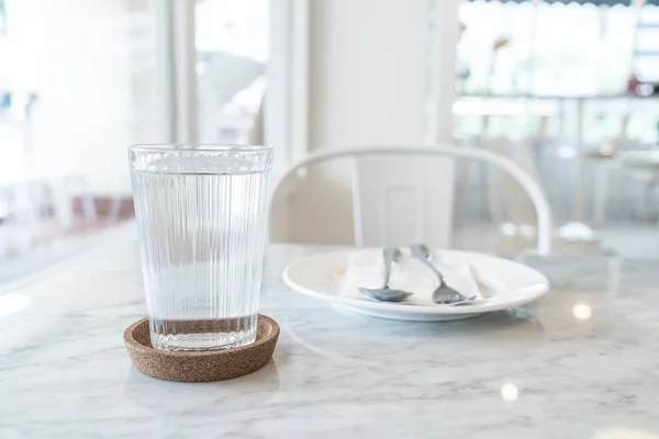 Стакан воды на обеденном столе — стоковое фото