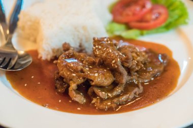 tavada kızartılmış baharatlı domuz eti pilav ile