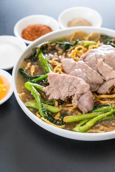 Crispy egg noodles with chinese broccoli and pork — Stock Photo, Image