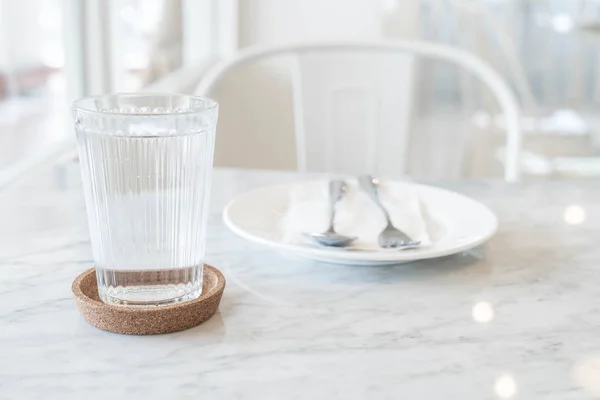 Стакан воды на обеденном столе — стоковое фото