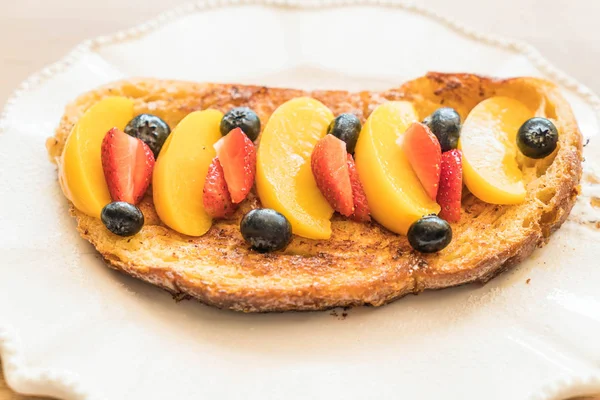 french toast with peach, strawberry and blueberries