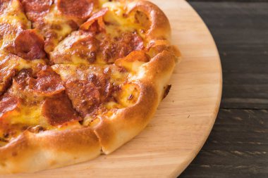 Ev yapımı biberli Pizza ahşap plaka üzerinde