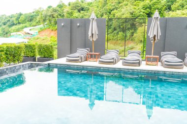 Güzel lüks şemsiye ve sandalye etrafında Açık Yüzme Havuzu