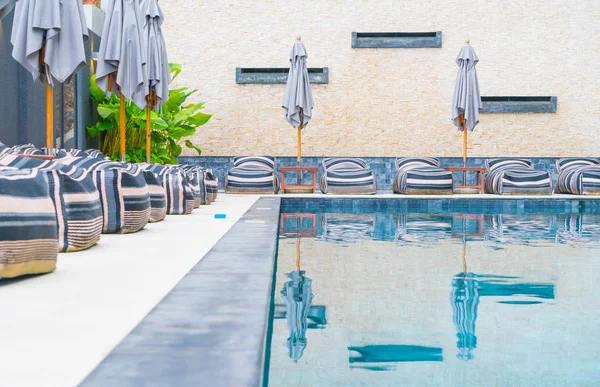 Belo guarda-chuva de luxo e cadeira em torno da piscina exterior — Fotografia de Stock