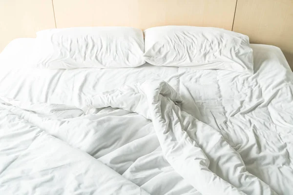 Смятая кровать с белой грязной подушкой — стоковое фото