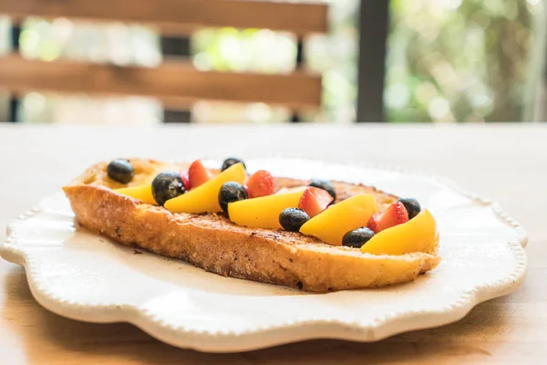 french toast with peach, strawberry and blueberries