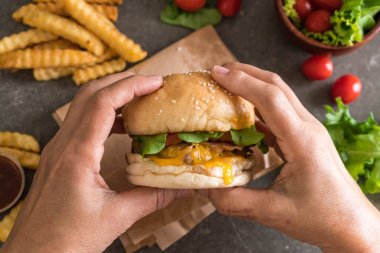 Taze lezzetli burger patates kızartması ve sos holding eller