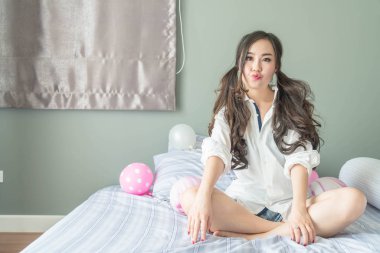 Yatakta yatıyordu yüz gülümseyen şirin Asyalı kadın 