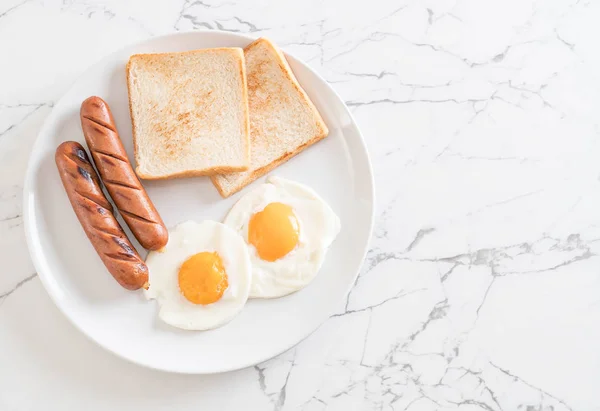 Жареные яйца с колбасой и хлебом — стоковое фото