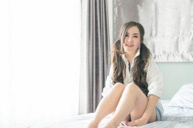 Yatakta yatıyordu yüz gülümseyen şirin Asyalı kadın 