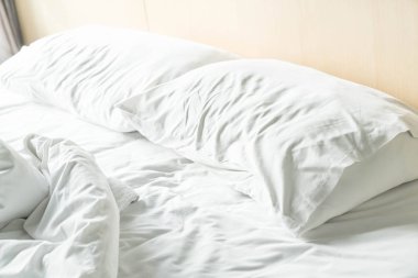 buruşuk yatak beyaz dağınık yastık ile 