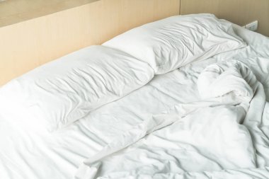 buruşuk yatak beyaz dağınık yastık ile 