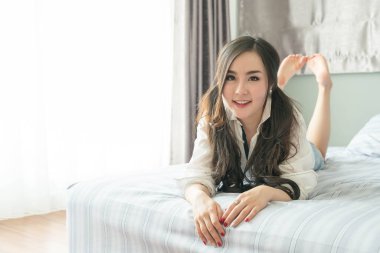 Yatakta yatıyordu yüz gülümseyen şirin Asyalı kadın 