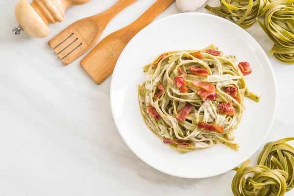 Spinach fettuccini pasta with bacon — Stock Photo, Image