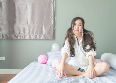 Yatakta yatıyordu yüz gülümseyen şirin Asyalı kadın 