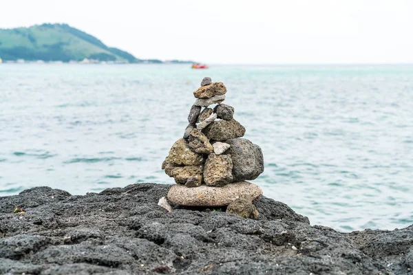 Torres de pedra sobre rochas basálticas em Hyeopjae Beach, Jeju Island — Fotografia de Stock