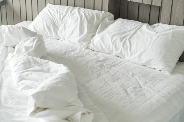 Cama enrugada com branco decoração travesseiro bagunçado no quarto — Fotografia de Stock