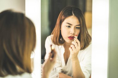 Genç güzel Asyalı ayna yakınındaki makyaj yapma kadın