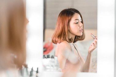 Genç güzel Asyalı ayna yakınındaki makyaj yapma kadın