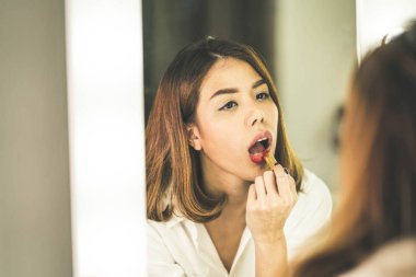 Genç güzel Asyalı ayna yakınındaki makyaj yapma kadın