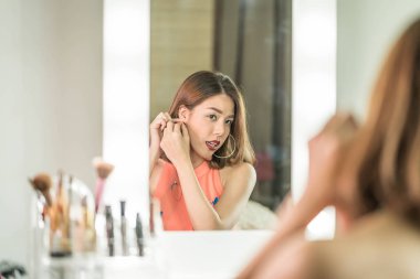 Genç güzel Asyalı ayna yakınındaki makyaj yapma kadın