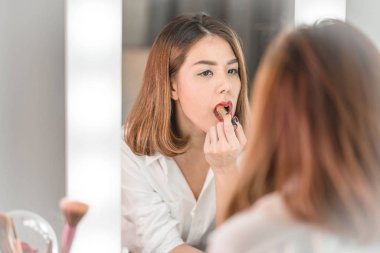 Genç güzel Asyalı ayna yakınındaki makyaj yapma kadın