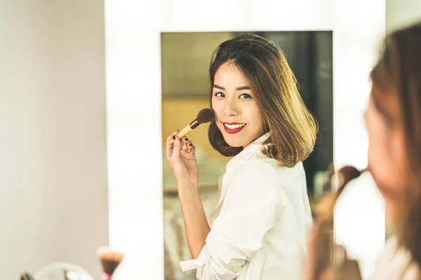 Genç güzel Asyalı ayna yakınındaki makyaj yapma kadın — Stok fotoğraf