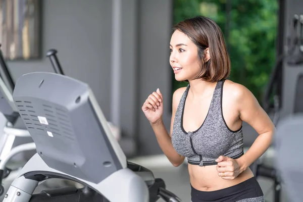 Jeune belle femme en vêtements de sport travaillant dans la salle de gym — Photo