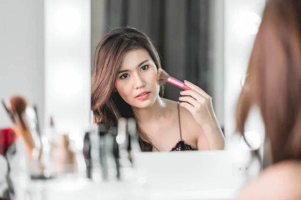 Junge schöne asiatische Frau Make-up in der Nähe von Spiegel — Stockfoto