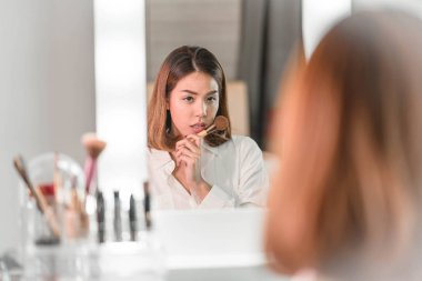 Genç güzel Asyalı ayna yakınındaki makyaj yapma kadın