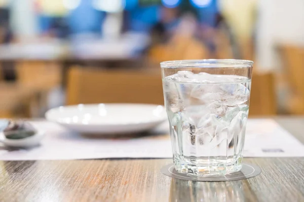 Vaso de agua sobre la mesa en el restaurante — Foto de Stock
